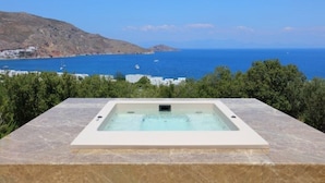 A spa area with a hot tub overlooking a coastal view. - Tilos Villa - Apartment Comfort (Tilos)