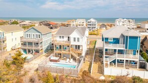 A coastal residential area with houses featuring balconies and a swimming pool. - Sun Realty gorgeous Nags Head home across the street from Jockey's Ridge (Nags Head)