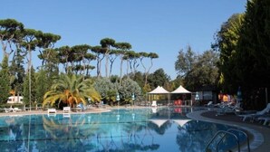A swimming pool with lounge chairs and a gazebo. - Mobile Home Roma, Camping Paradiso, Viareggio, (Viareggio)