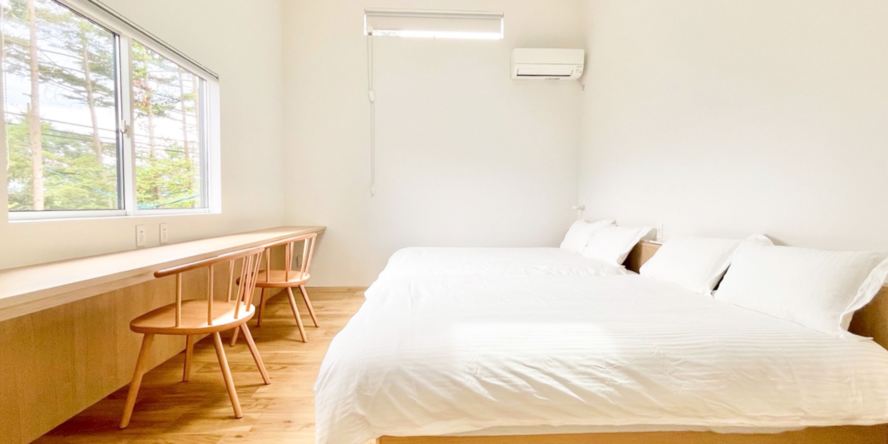 Een slaapkamer met een bed, een bureau en stoelen.