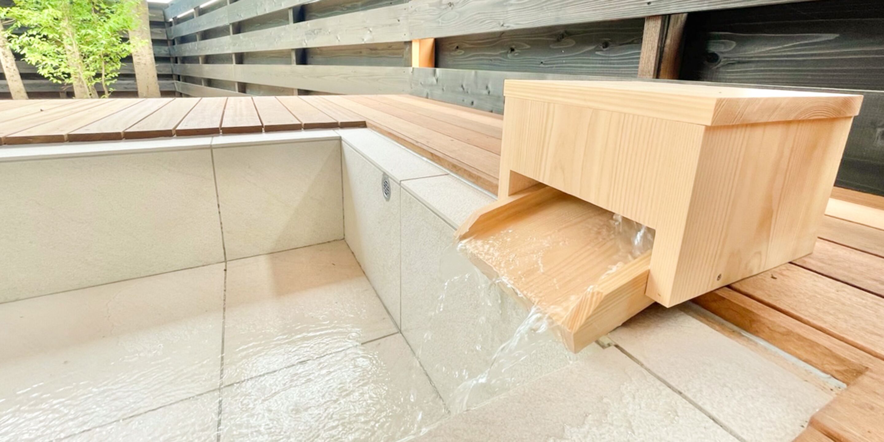 Une terrasse en bois avec un jacuzzi intégré.