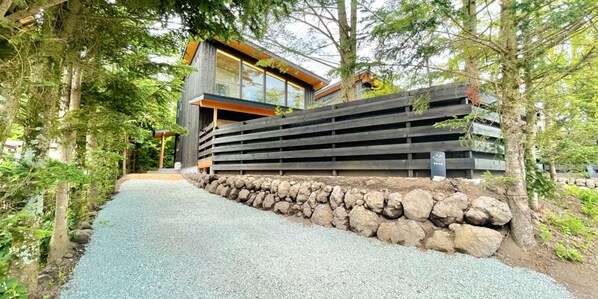 A modern building with a stone retaining wall and a gravel path leading to it. - KARUIZAWAHOUSE VILLA (Karuizawa)