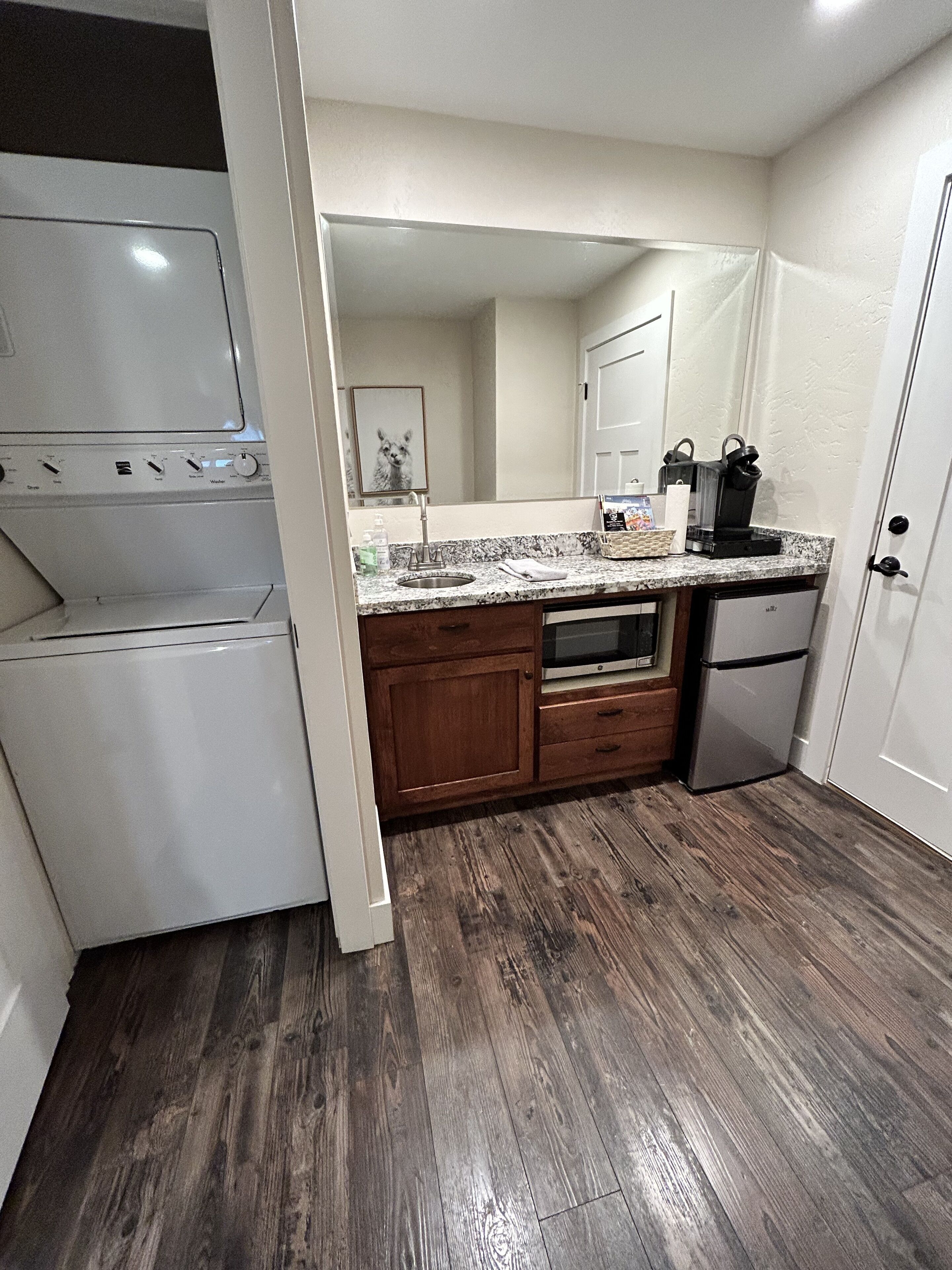 A kitchen with a built-in oven, a microwave, a sink, and a refrigerator.