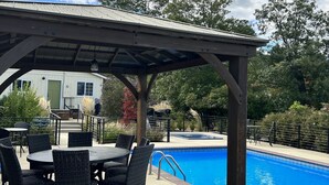 A covered patio area with outdoor seating and a swimming pool. - The Rellik House and Winery (Central Point)