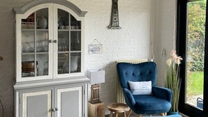 A room with a white cabinet, a blue armchair, and a small stool. - Idyllic, detached vacation home on the Grevelingenmeer (Herkingen)