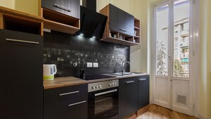 A modern kitchen with dark cabinetry, a black countertop, and a wooden floor. - Fabbroni 3 bedrooms by Mmega (Florence)