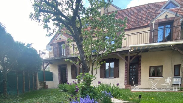 Una casa de dos pisos con un jardín delantero.