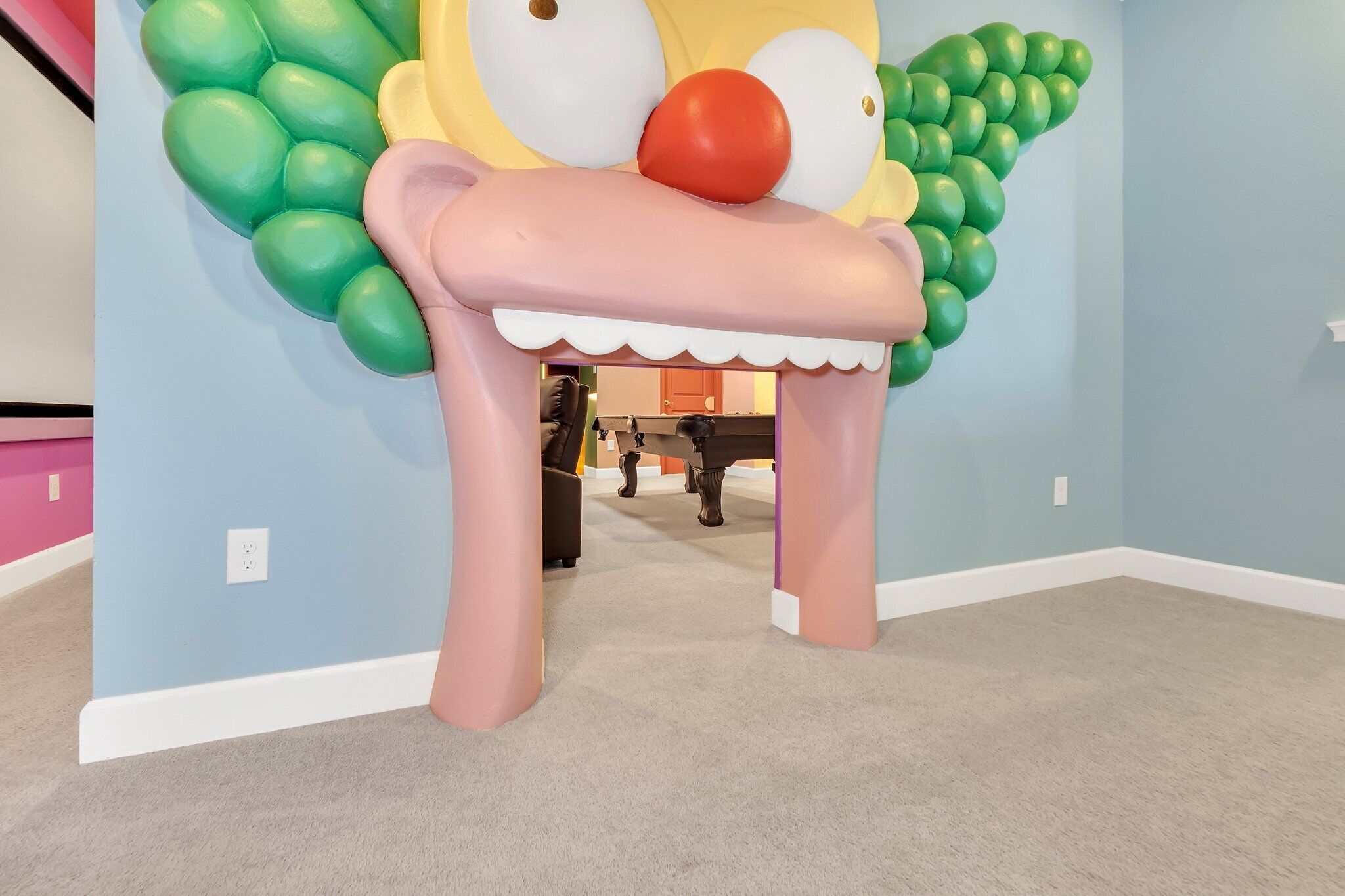 Une pièce décorée de nombreux ballons colorés, formant une grande composition qui ressemble à un personnage.