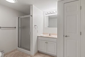 A bathroom with a shower, a sink, a vanity, and a mirror with lights. - Direct Ocean Front Unit With Private Balcony. (Old Orchard Beach)