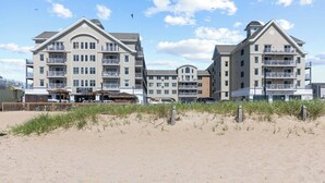 Un hôtel situé en bord de mer, doté de nombreux balcons, d’un restaurant au bord de la plage et d’une zone de plage de sable.