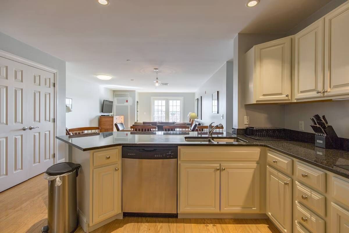 A modern kitchen with a dishwasher, a sink, and a countertop with knives.