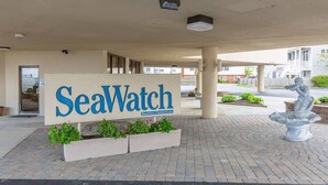 A SeaWatch Beachfront Condominium sign with a planter and a statue in front. - Oceanfront Seawatch Condo unit 402 (Old Orchard Beach)