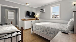 A bedroom with a bed, a TV, a window, and a kitchenette. - Seaside Village Condo #3- 300 ft to Sandy Beaches! (Old Orchard Beach)