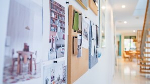 A wall with various photographs and papers pinned to it, suggesting a personal or work-related display. - StayAU 4BR Designer Home in Knox (Wantirna South)