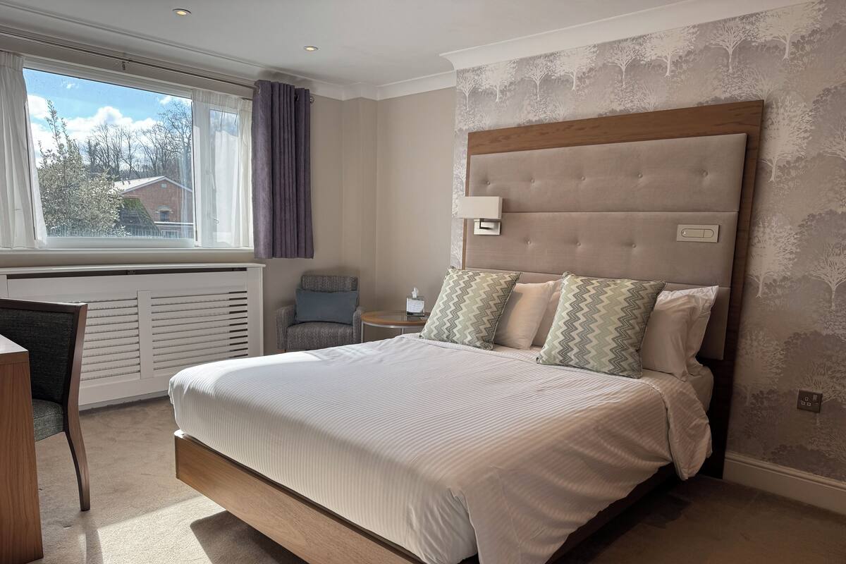 Une chambre à coucher moderne avec un grand lit, un bureau et une chaise.