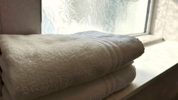 A white towel folded neatly on a window sill.