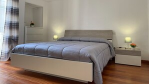 Una camera da letto moderna con un letto, comodini e un tavolino da notte.