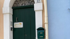 Una porta verde a due ante con una targa che riporta la scritta “HOUSE RELAX” e una cassetta delle lettere sulla destra.