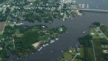 An aerial view of a coastal town with a marina, residential areas, and a bridge connecting two land masses.