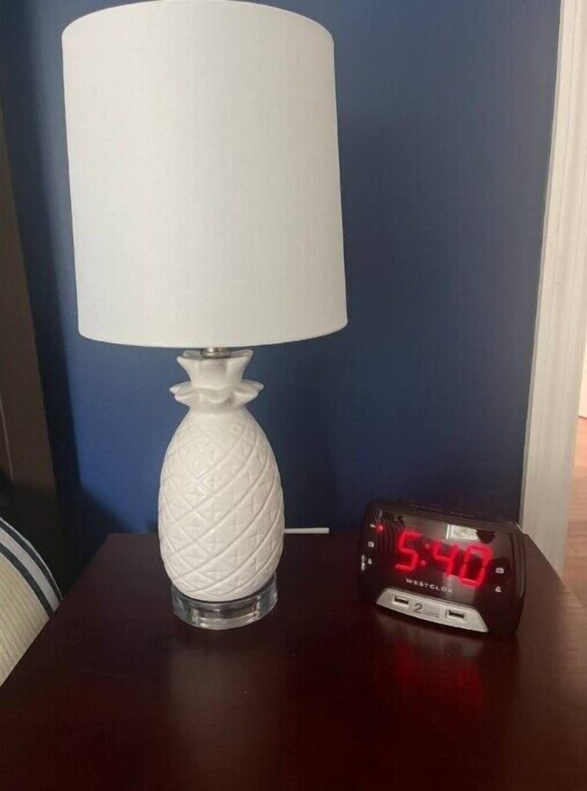 Une lampe blanche avec un pied texturé et un affichage numérique indiquant 5 h 40.