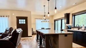 A modern kitchen with a central island, dark cabinetry, and pendant lighting. - Moonlit Summit with hot tub, lots of great parking and views (Lead)