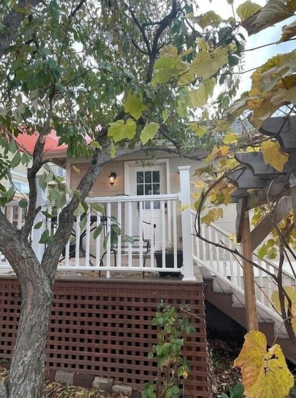 A house with a porch, a red roof, and a white fence. - Luxuriously comfortable & peaceful getaway downtown Ashland, with views.   (Ashland)