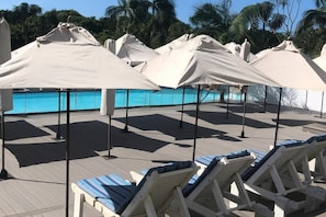 A poolside area with lounge chairs and umbrellas. - Studio Resort Apartment - Sleeps 2 - Beachside (Umhlanga)
