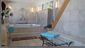 Un baño con bañera, tocador, espejo y ventana.