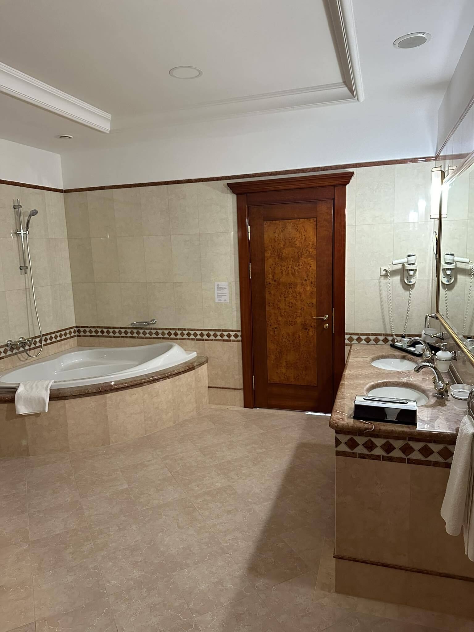Ein Badezimmer mit einer freistehenden Badewanne, einem Waschtisch und einem großen Spiegel.