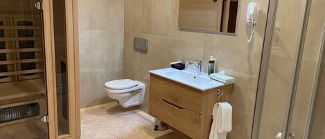 A modern bathroom with a glass shower enclosure, a toilet, and a vanity with a mirror.