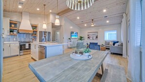 Une cuisine spacieuse avec un plafond en bois, des appareils modernes et un îlot central.