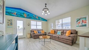 Ein Wohnzimmer mit zwei braunen Sofas, einem Couchtisch und einem Wandgemälde.