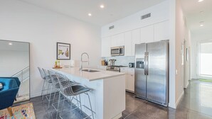 A modern kitchen with a stainless steel refrigerator, a microwave, and a gas stove. - Zanjero by Avantstay Mins From Downtown Palm Springs Private Terrace, Shared Pool (Palm Springs)