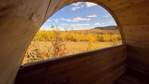 A view through a wooden window of a landscape with autumn foliage and a clear sky. - Modern Timber- Hot tub, sauna, theatre, climb wall (Beaver Mines)