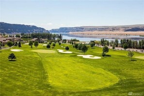 A golf course with bunkers, trees, and a lake in the background. - #154 Kater's Kabin 3-Condo near large pool & Gorge shuttle-book separately (Quincy)