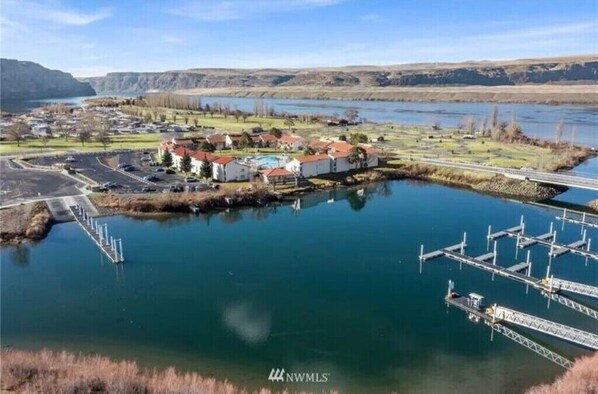 A lakeside property with a dock, a bridge, and a small building with a red roof. - #182-Unit by pool & Gorge shuttle-book separately (Quincy)