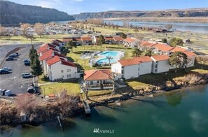 A residential area with houses, a swimming pool, and a body of water. - #182-Unit by pool & Gorge shuttle-book separately (Quincy)