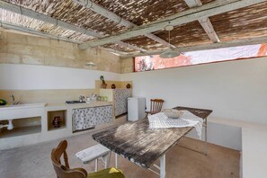 Una cocina rústica con una mesa de madera, un lavamanos y un refrigerador.