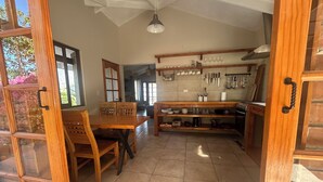 A spacious kitchen with wooden furniture, a dining area, and a view of the outdoors. - Elqui Valley Avocado Farm, 2-bedroom cabin in fabulous Vicuña with WiFi (Vicuña)
