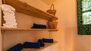Wooden shelves with towels and a woven basket. - Family room with balcon - Explore semplicity immerse yourself in nature  (Michamvi Kae)