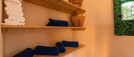 Wooden shelves with towels and a woven basket.