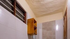 A compact bathroom with a toilet, sink, and shower area. - Nazi - Explore semplicity, savor local cousine, immerse yourself in nature  (Michamvi Kae)
