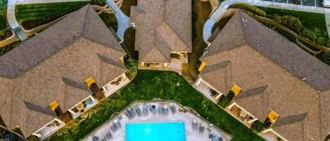 A residential complex with multiple houses, a central swimming pool, and a parking area.