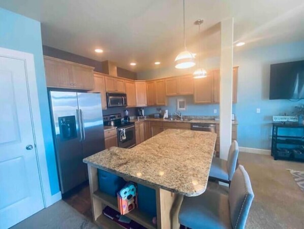 A modern kitchen with granite countertops, stainless steel appliances, and wooden cabinets. - A66-Condo by pool & golf course (Quincy)