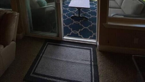 A room with a sliding glass door leading to an outdoor patio with a table and a couch. - A28 condo by large pool/shuttle (Quincy)