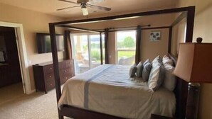 A bedroom with a four-poster bed, a ceiling fan, and a view of the outdoors. - A28 condo by large pool/shuttle (Quincy)