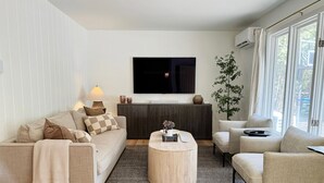 A modern living room with a sofa, armchair, and round coffee table. - Downtown Sister Bay | Arcade, Deck, Fire Pit (Sister Bay)