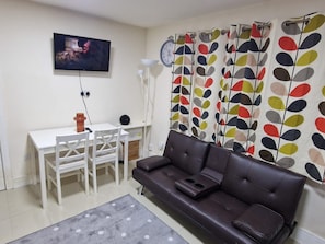 Cozy living space with a dining table, sofa, and television.