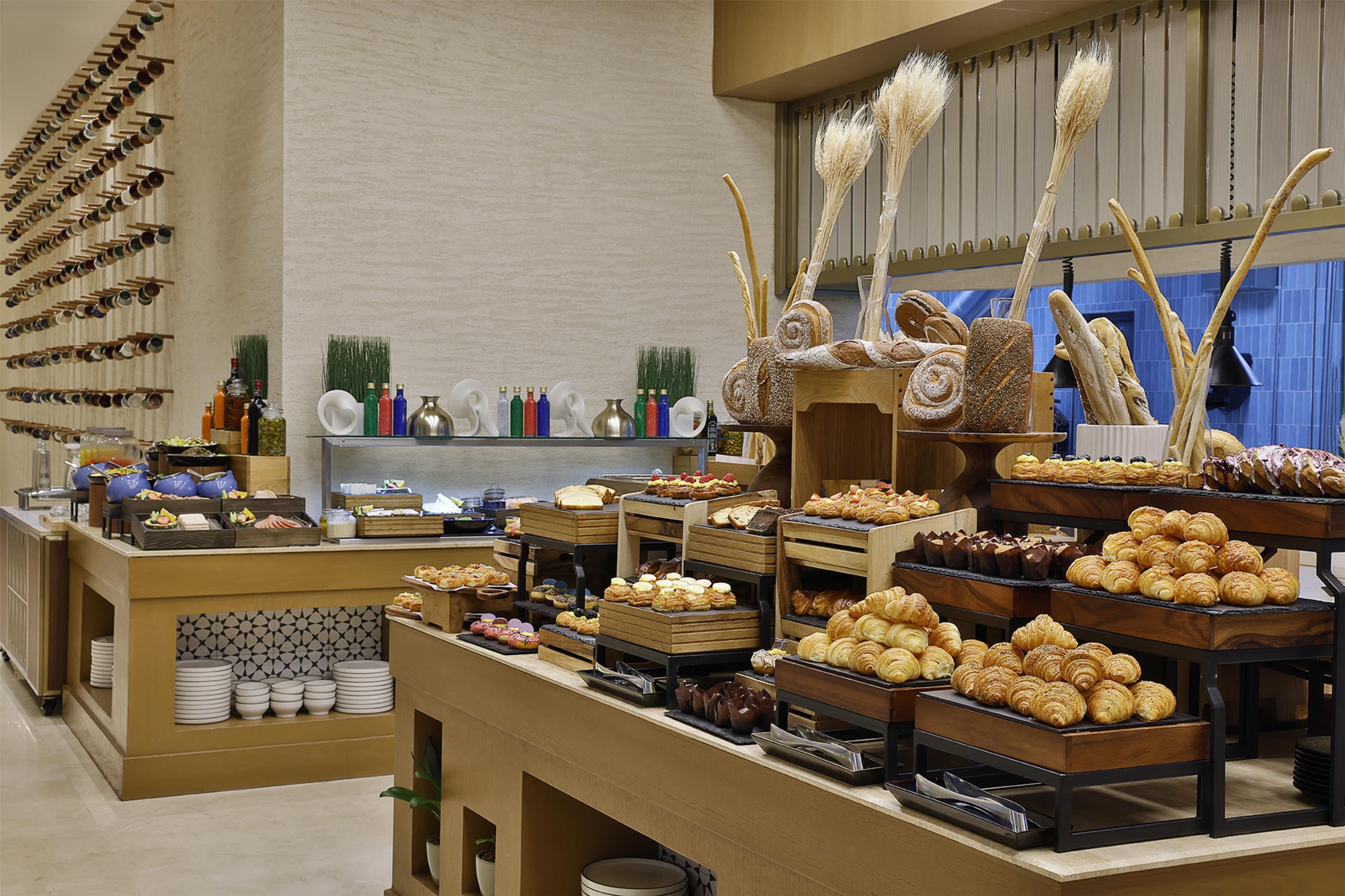 Een buffet met diverse gerechten en een wijnrek.