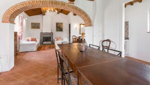 A dining area with a long wooden table, chairs, and a chandelier. - Private Villa with private pool, A/C, WIFI, TV, patio, panoramic view, close to Montepulciano (Scrofiano)